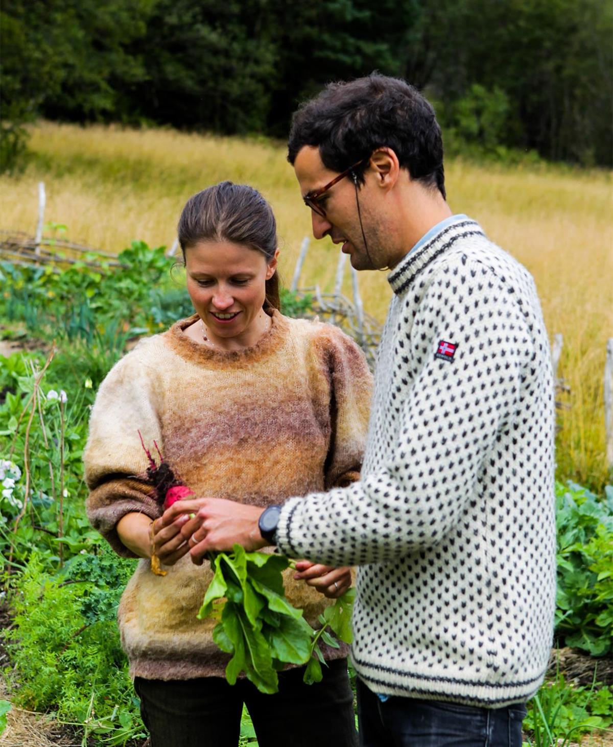 Kvinne og mann inspiserer grønnsaker fra egen hage. - Klikk for stort bilde